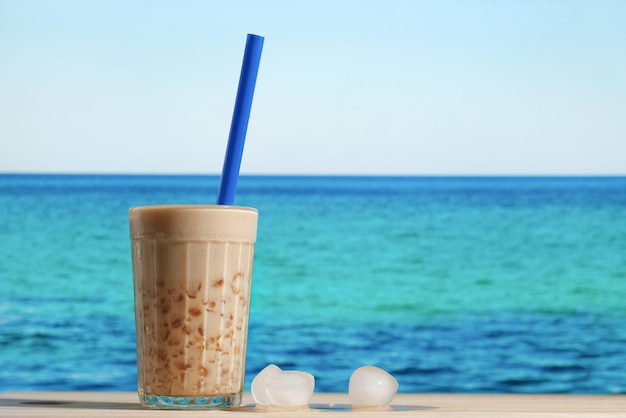 Vaso de té de burbujas frío en la playa de verano