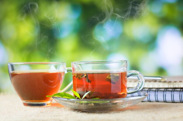 un vaso de té caliente en un saco de cáñamo y mesa por la mañana