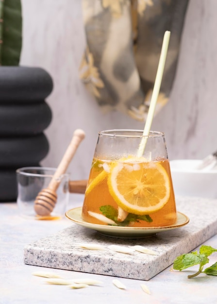 Vaso de té helado de limón fresco con hierba de limón sobre una mesa de mármol blanco. Enfoque selectivo. De cerca