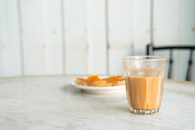 Vaso de té con leche tailandesa caliente en la mesa