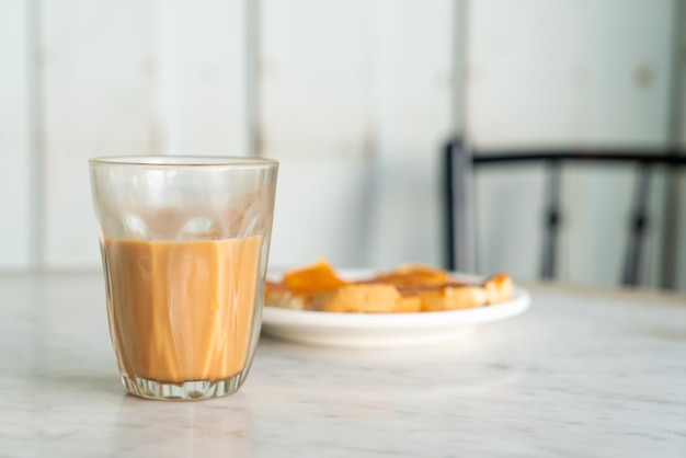 Vaso de té con leche tailandesa caliente en la mesa