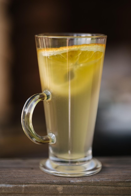 Un vaso de té de limón con mango y una rodaja de limón.