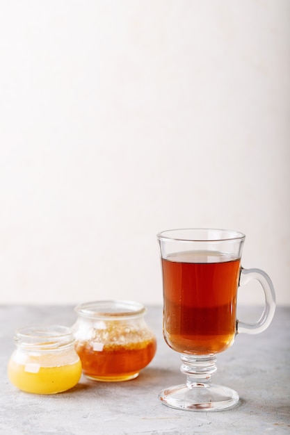 Vaso de té negro servido con miel
