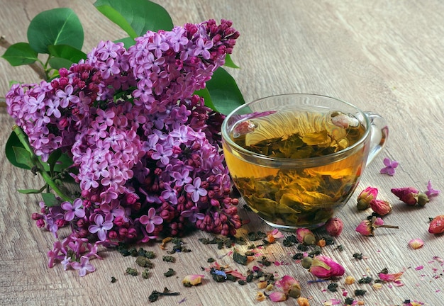 un vaso de té con un ramo de flores moradas