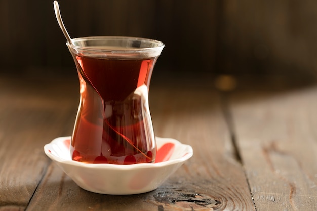 Vaso con té turco sobre tabla de madera