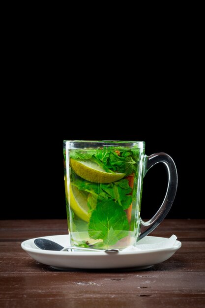 Foto vaso de té verde con lima, limón, menta.