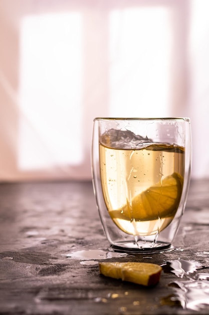 Foto un vaso de té verde con limón en una mesa