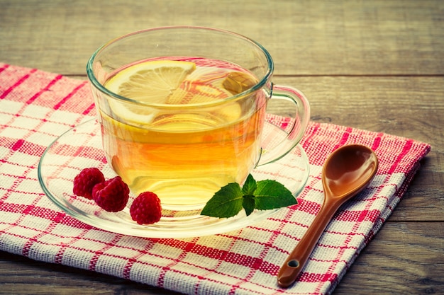 Vaso de té verde con un platillo y la rodaja de limón