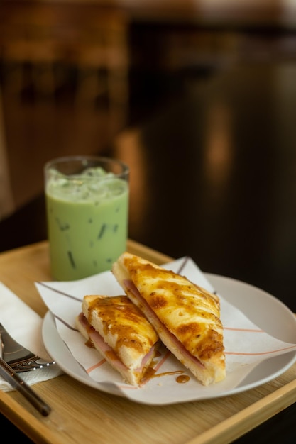 Un vaso de té verde se sienta al lado de un plato de comida.