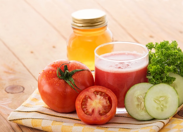 Un vaso de tomate fresco mezcla jugo de pepino con ingredientes