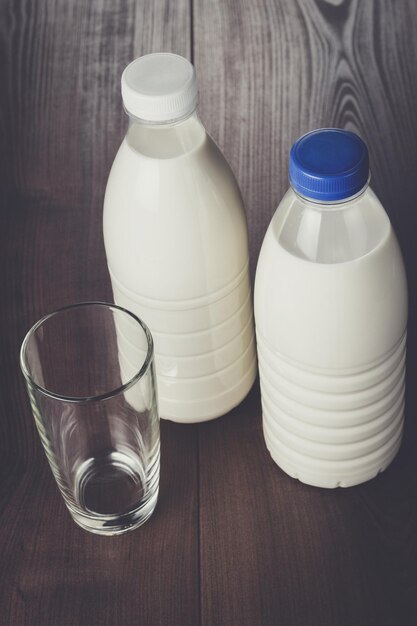 Foto vaso vacío y dos botellas de leche.