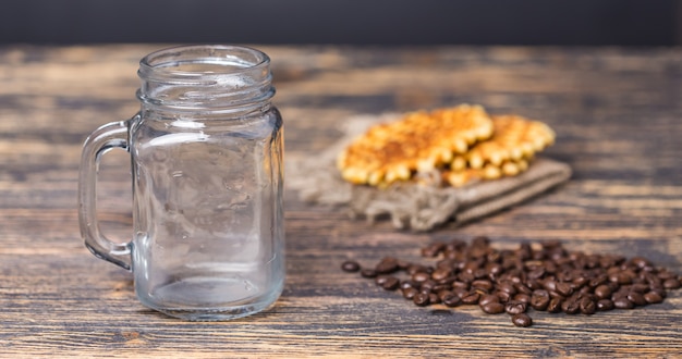 Vaso vacío y granos de café en el fondo.