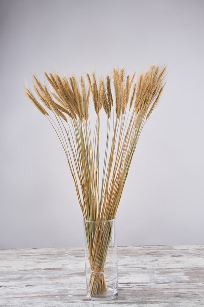 Vaso vertical de vidro com espigas de trigo douradas