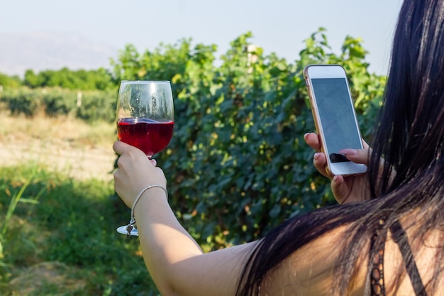 un vaso de vino en la mano en el viñedo