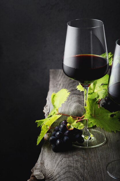 Un vaso de vino tinto de cerca en una vieja mesa de madera