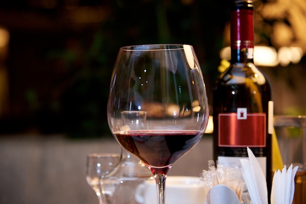 Un vaso de vino tinto en una mesa servida en un restaurante.