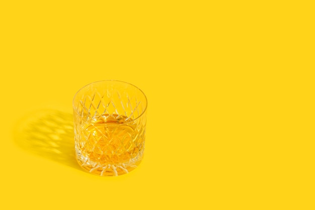 Un vaso de whisky en un amarillo.