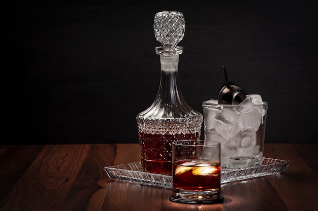 Vaso de whisky con una botella y un cubo de hielo de vidrio
