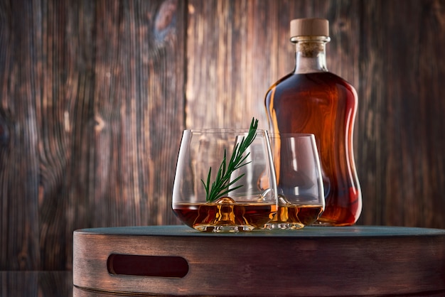 Vaso de whisky y una botella en la mesa de madera