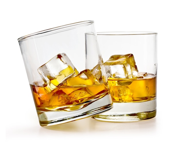 Vaso de whisky escocés y hielo en blanco