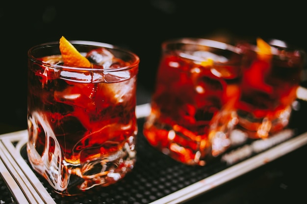 Vaso de whisky escocés y hielo en el fondo del procesamiento de fotos antiguas del bar