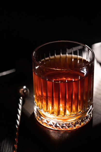 Vaso de whisky facetado en una mesa de madera negra Vista superior