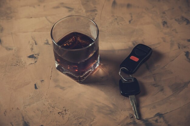 Vaso de whisky y la llave del coche en la mesa