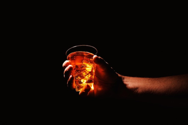 Foto vaso de whisky en la mano de un hombre