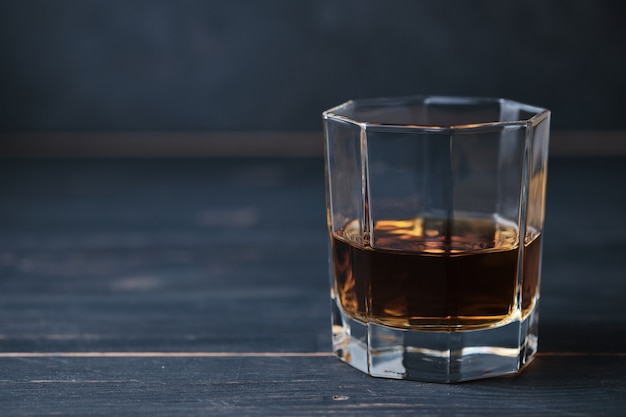 Vaso de whisky en una mesa de madera en un bar. Barra de bar con bebida alcohólica.