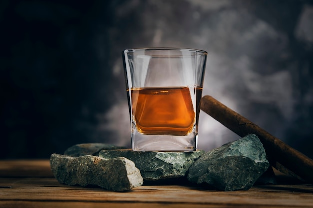 Foto vaso de whisky y puro en piedra