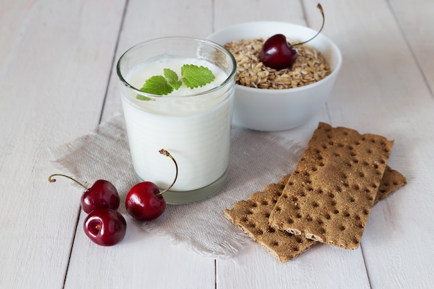 Foto vaso de yogur, pan crujiente y cereal