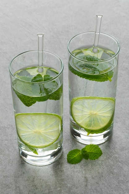 Vasos con agua de lima y hojas de menta