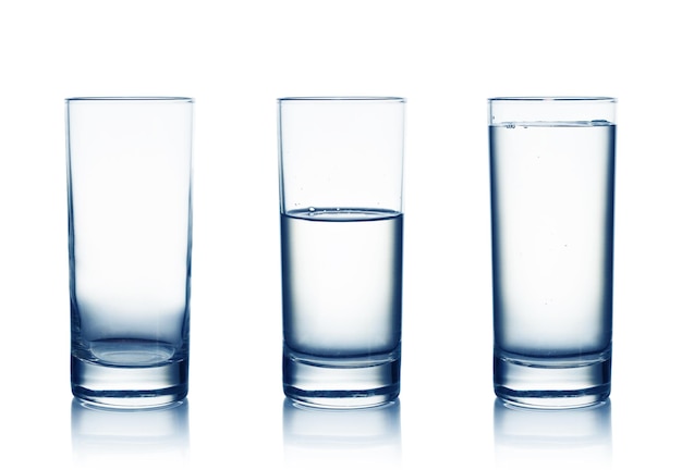 Vasos de agua llenos y medio vacíos aislados en blanco