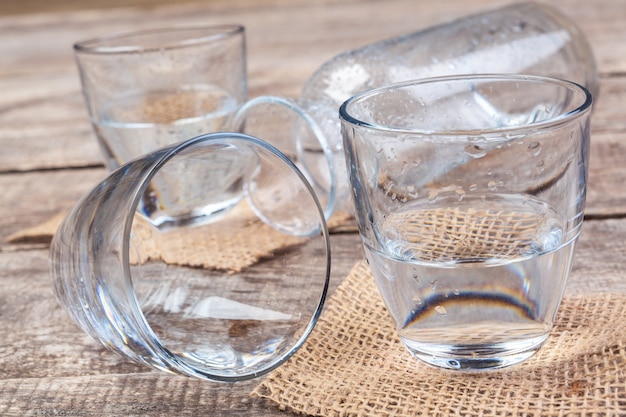 Vasos de agua sobre una mesa de madera.