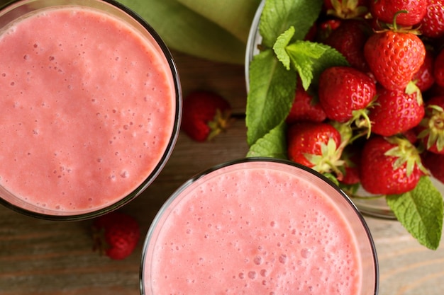 Vasos de batido con fresas en la mesa de cerca