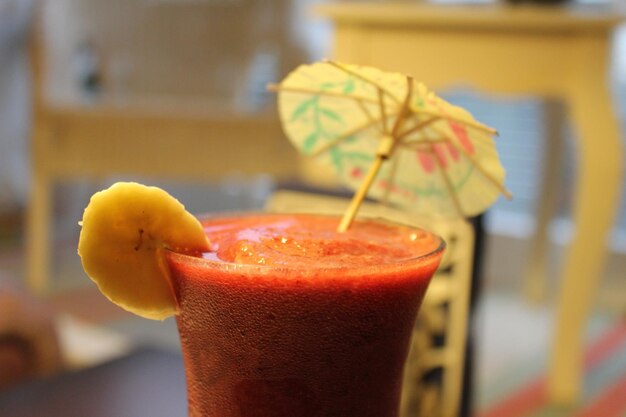 Vasos de batido frío fresco con frutas y bayas en el primer plano de la mesa