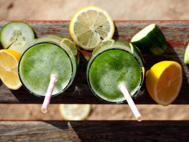 Vasos con batidos verdes verduras y frutas.