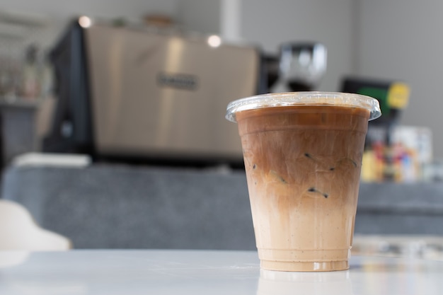 Los vasos para beber están sobre la mesa y hay una máquina de café en el fondo.