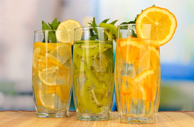 Vasos de bebidas de frutas con cubitos de hielo en la mesa de café