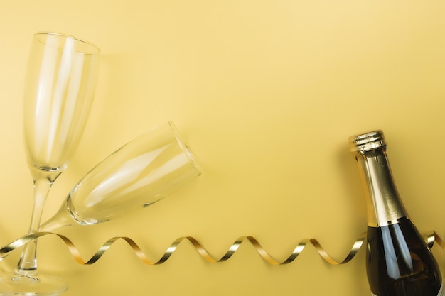 Vasos, botella de vino espumoso y cinta dorada