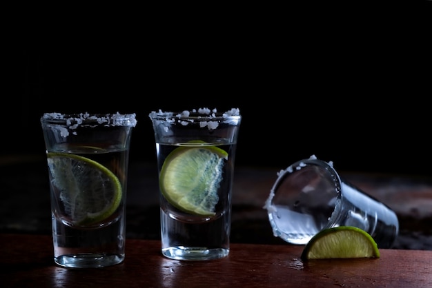 Vasos de chupito de tequila con sal y lima.