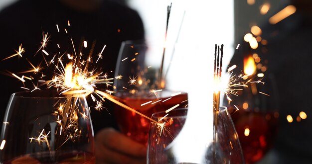 Vasos con cócteles alcohólicos y luces de Bengala closeup