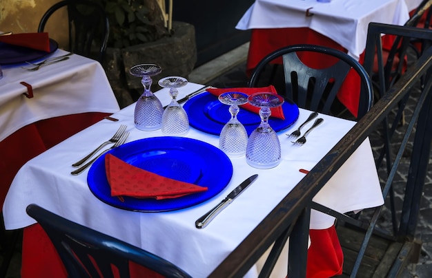 Vasos, cucharas, platos y tenedores en la mesa del restaurante