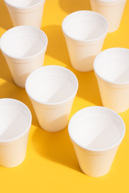 Foto vasos desechables vacíos sobre un fondo amarillo en una vista superior