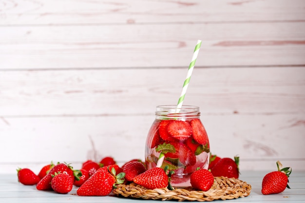 Vasos de fresas, agua infundida de menta con hielo