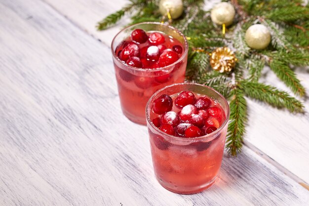 Vasos con jugo de arándanos en madera blanca