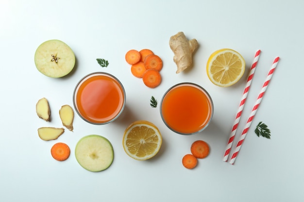 Vasos de jugo e ingredientes sobre fondo blanco aislado