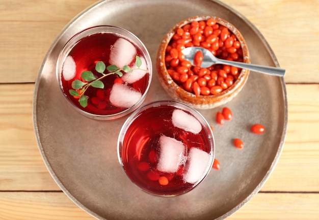 Vasos con jugo de goji en bandeja de metal