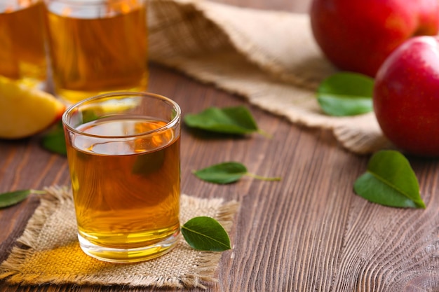 Vasos de jugo de manzana y frutas en la mesa de cerca