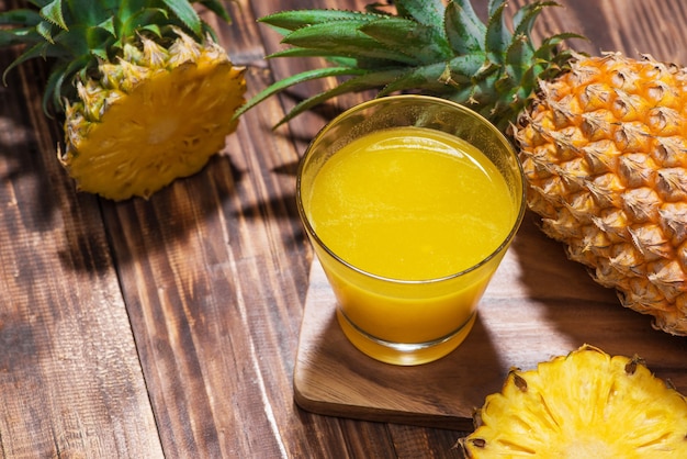 Vasos de jugo de piña en una mesa de madera